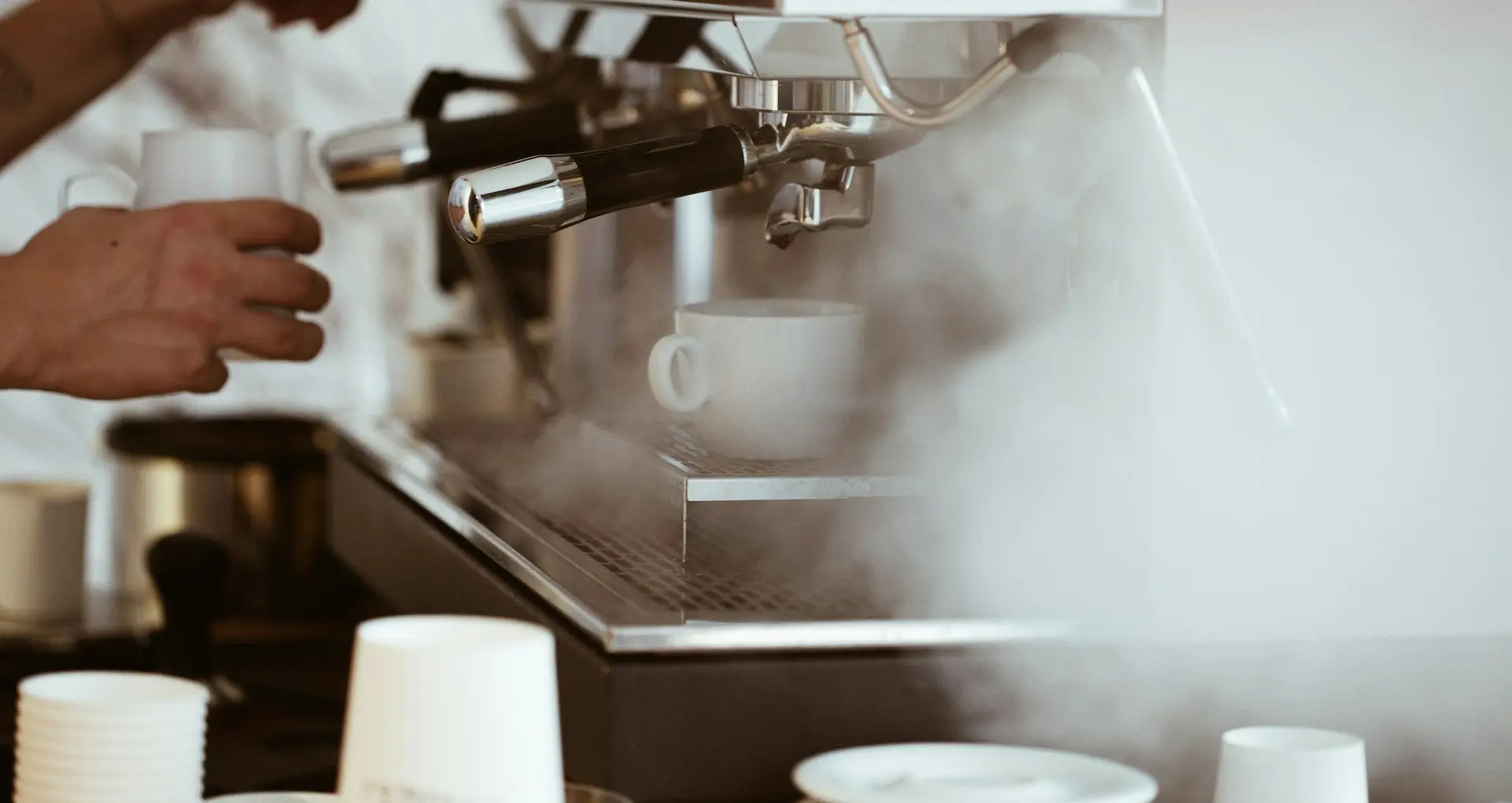 person holding white mug brewing coffee
